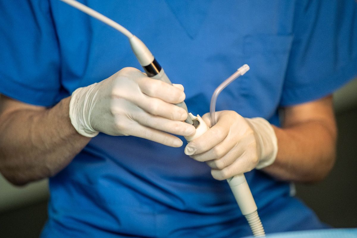 Mani con strumenti odontoiatrici di precisione durante un trattamento conservativo